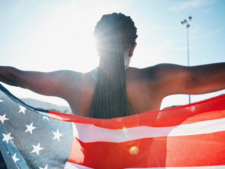 An Olympian athlete holding the American flag