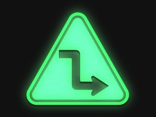 green road sign showing a sharp turn