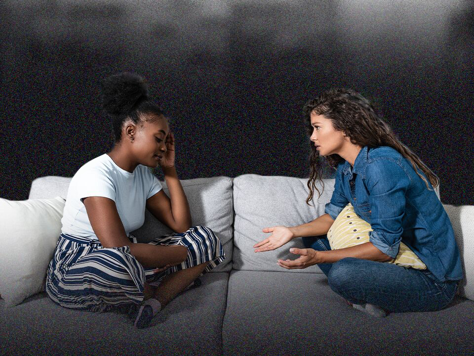 two people talking on a couch about how to help a friend through a breakup