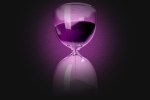 An hourglass in a purple shadow