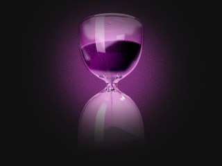 An hourglass in a purple shadow