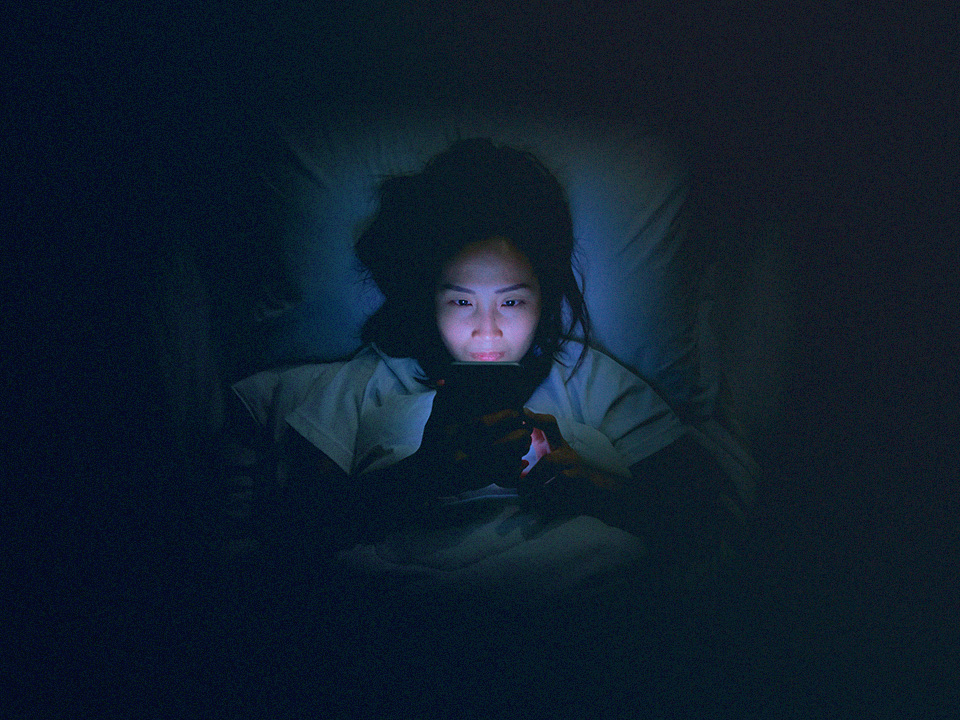 someone staying up too late to scroll on their phone because they have revenge bedtime procrastination